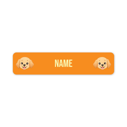 An orange rectangular label with rounded corners, featuring two cartoon puppy faces at the left and right edges and the word 'NAME' in the centre, shown on a plain white background.