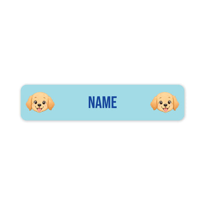 A horizontal light blue personalized name label with rounded corners, featuring two cartoon puppy faces on the left and right sides and the word 'NAME' in blue text in the center, shown on a white background.
