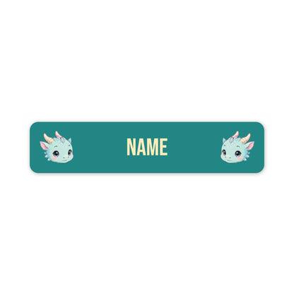 A teal rectangular label with rounded corners, featuring two small cartoon unicorn faces on the left and right sides and the word 'NAME' in the centre, shown on a plain white background.