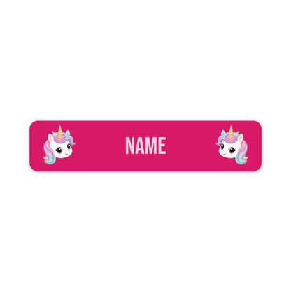 A pink rectangular name tag with rounded corners, featuring two cartoon unicorn illustrations on the left and right sides and the word 'NAME' in the center for personalization.