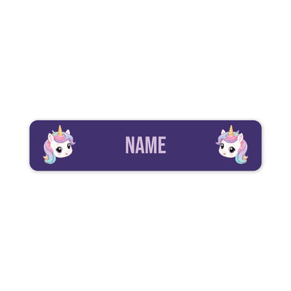 A purple rectangular name tag with rounded corners, featuring two cartoon unicorn illustrations on the left and right sides and the word 'NAME' in the center for personalization.